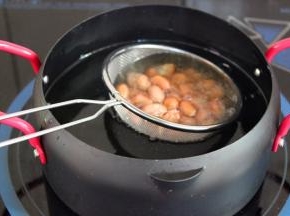 用油锅炸熟花生米，捞出沥干油；