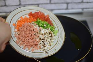 锅中油热，加菜末、火腿肠末炒两分钟