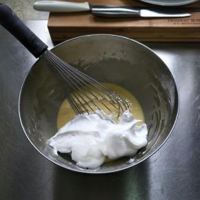 将蛋白霜分三次加入蛋黄糊中，用手抽拌匀…