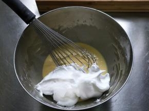 将蛋白霜分三次加入蛋黄糊中，用手抽拌匀…