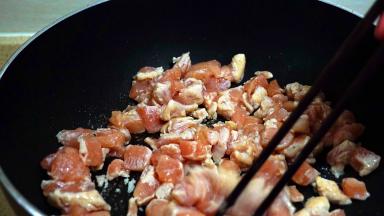 锅中加少许油，下入鸡丁翻炒。