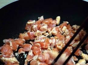 锅中加少许油，下入鸡丁翻炒。