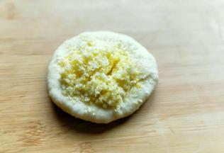 取一小块面团，用擀面杖擀开，放入做好的椰蓉馅。像包包子一样的手法包起来，收口朝下，用手掌轻轻按压！
