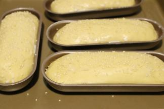 发酵好的热狗胚表面刷上牛奶，撒上芝麻。