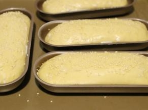 发酵好的热狗胚表面刷上牛奶，撒上芝麻。