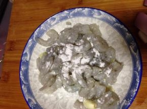 腌制好的虾仁捡出葱段，加入淀粉和几滴食用油抓匀上浆