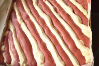 间隔着把面糊挤入烤盘。最后震一下震出大气泡。