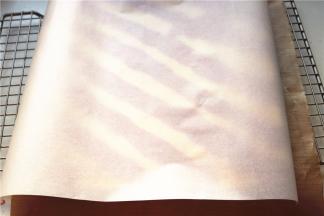 揭下底部油纸，再次盖上一张干净的油纸，再次倒扣过来。