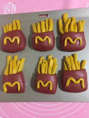 用预留的黄色面条搓成圆条，做出“m”形状，沾少许水，粘在红色“袋子”上！