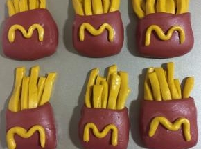 用预留的黄色面条搓成圆条，做出“m”形状，沾少许水，粘在红色“袋子”上！