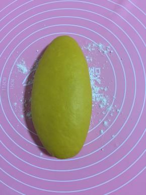 硅胶揉面垫上撒少许面粉，把黄色面团放在垫子上揉匀！