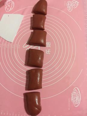 垫子上撒少许面粉，把红色面团揉匀搓成长条，切成6份备用！