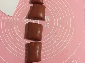 垫子上撒少许面粉，把红色面团揉匀搓成长条，切成6份备用！
