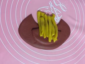 把一份黄色的面团一根一根的码放在面片中间，不要码放的太整齐，这样做出来的更像薯条！