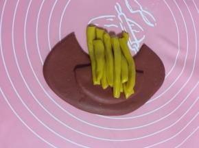 把一份黄色的面团一根一根的码放在面片中间，不要码放的太整齐，这样做出来的更像薯条！