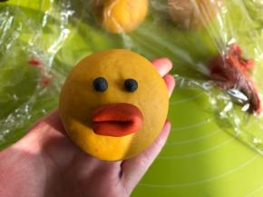 莎莉鸡的眼睛用黑色面团，把橘色面团取一点搓成长条，对折，粘在莎莉鸡的脸上