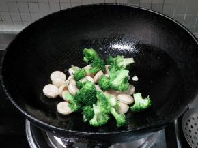 倒入沥干水分的西兰花翻炒均匀。