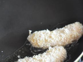 再裹上面包糠，煎锅里倒入油，将鱼肠放入里面，小火煎炸。