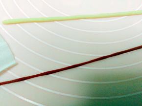 白面团搓成粗条，深红曲面团搓成细条，绕在白面条上，粘好，做帽子围边