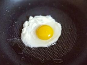 煎荷包蛋，油温8成时加入鸡蛋，可以用铲子稍做整形，煎至蛋白凝固即可。