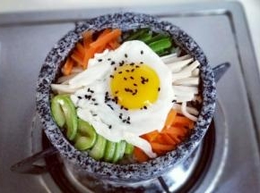 将煎好的鸡蛋放入蔬菜上面，撒上少许熟黑芝麻，开小火大约3-5分钟，听到米饭发出滋拉滋拉的声音可以关火，锅底的米饭会有有一层锅巴，特别香。(一定要小火，一定要小火，一定要小火，重要的事情说三遍。）