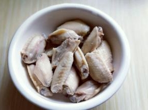 捞出后立即过冷水，反复冲洗，将鸡翅的杂质冲洗干净，装入大口器具中。