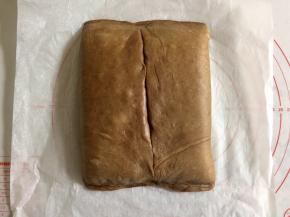 把面皮两侧往中间折，把黄油片包住，上下口捏紧，中间如果不太重合也捏紧。