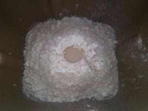 将面团中除黄油以外的材料按下层液体，中层粉体，上层酵母的顺序放进面包机桶中，按揉面程序开始揉面，揉成光滑面团时加入软化的黄油继续揉。