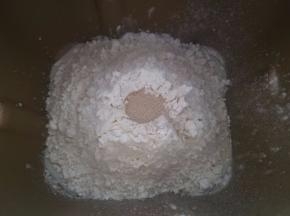 将面团中除黄油以外的材料按下层液体，中层粉体，上层酵母的顺序放进面包机桶中，按揉面程序开始揉面，揉成光滑面团时加入软化的黄油继续揉。