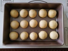 将15个小面团揉圆，放到烤盘里。放入烤箱二次发酵，烤箱里放碗热水。