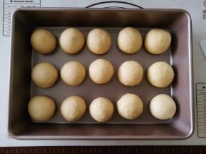 将15个小面团揉圆，放到烤盘里。放入烤箱二次发酵，烤箱里放碗热水。
