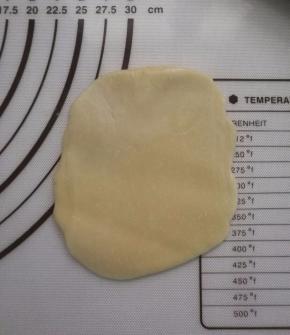 将面卷从中间压一下，再两边往中间一捏，压扁，擀成圆片