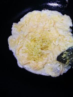 倒入姜末，和鸡蛋翻炒混合。