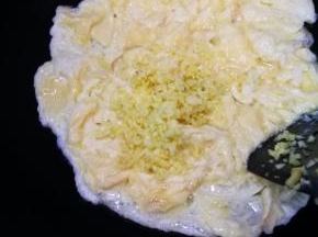 倒入姜末，和鸡蛋翻炒混合。