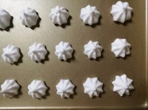 混合好的蛋白霜装入裱花袋中，将蛋白霜均匀的挤在烤盘内。