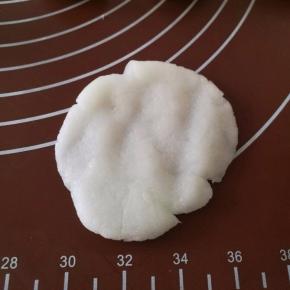 白色的月饼皮按扁成中间厚，四周薄的面片。