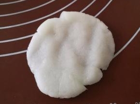 白色的月饼皮按扁成中间厚，四周薄的面片。