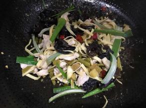 肉的颜色发白时放入酸豆角、黑木耳和干红椒，最后放入蒜叶，加少许盐