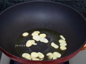 热锅，倒入食用油，下蒜片爆香