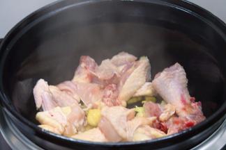 锅内发出滋滋的声音时，倒入鸡肉，用木铲翻炒均匀