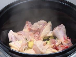 锅内发出滋滋的声音时，倒入鸡肉，用木铲翻炒均匀