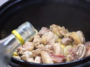 炒至鸡肉表面发白，鸡皮紧缩，再烹入料酒