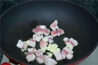 热锅，倒入少量食用油，倒入五花肉、蒜头大火干煸出香味