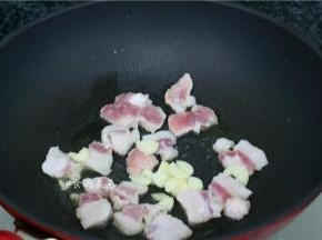 热锅，倒入少量食用油，倒入五花肉、蒜头大火干煸出香味