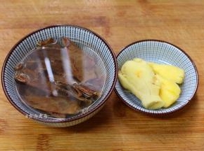 生姜去皮拍扁，墨鱼干用开水浸泡片刻，洗净