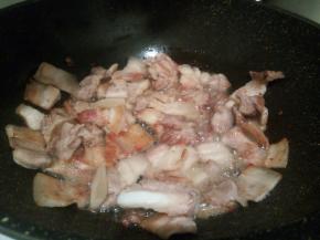 煸炒至五花肉微黄，打卷