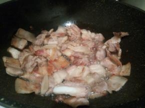 煸炒至五花肉微黄，打卷