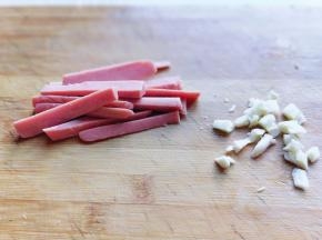 x火腿肠去皮切条，蒜去皮切碎。