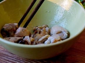 生蚝去壳，加入几滴食用油，用筷子顺一个方向轻轻转动，去掉生蚝的碎壳，再冲洗干净