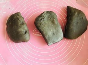 第一次发酵结束，将面团放置于硅胶垫上，轻轻拍扁。分割成3份。